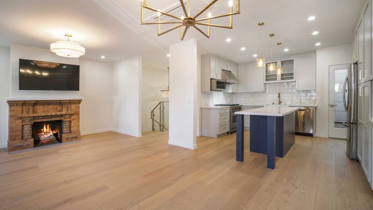 Open-plan living room with a brick fireplace in a renovated Noe Valley home, San Francisco