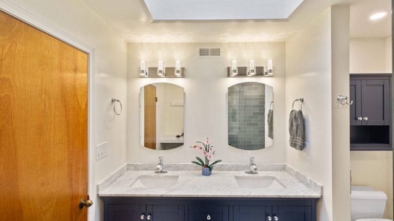 Marble double-vanity bathroom in a San Francisco home with polished stone and warm metal fixtures